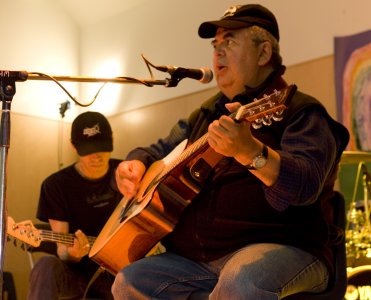 Bob Charlie sings as he plays his guitar.