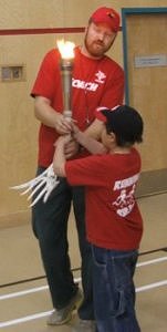 Dustin hands the torch to Nathaniel Schafer who did two of fourteen laps around the gym for the provinces and territories Canada