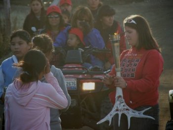 Lindsay holds the torch while the next person gets ready to walk with the torch