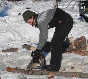 Rhonda helping saw some wood.